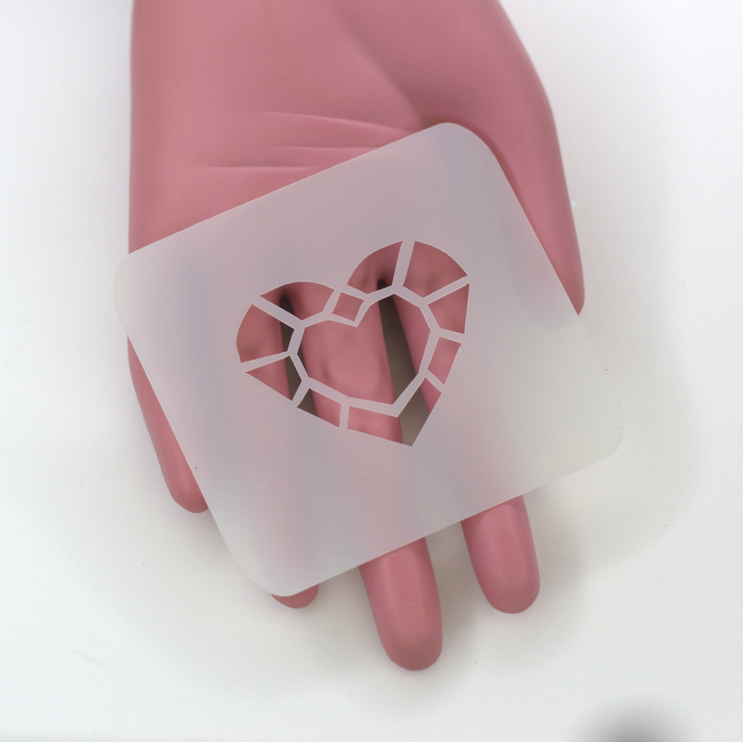 plastic stencil heart shaped like a gem cut on plastic pink hand