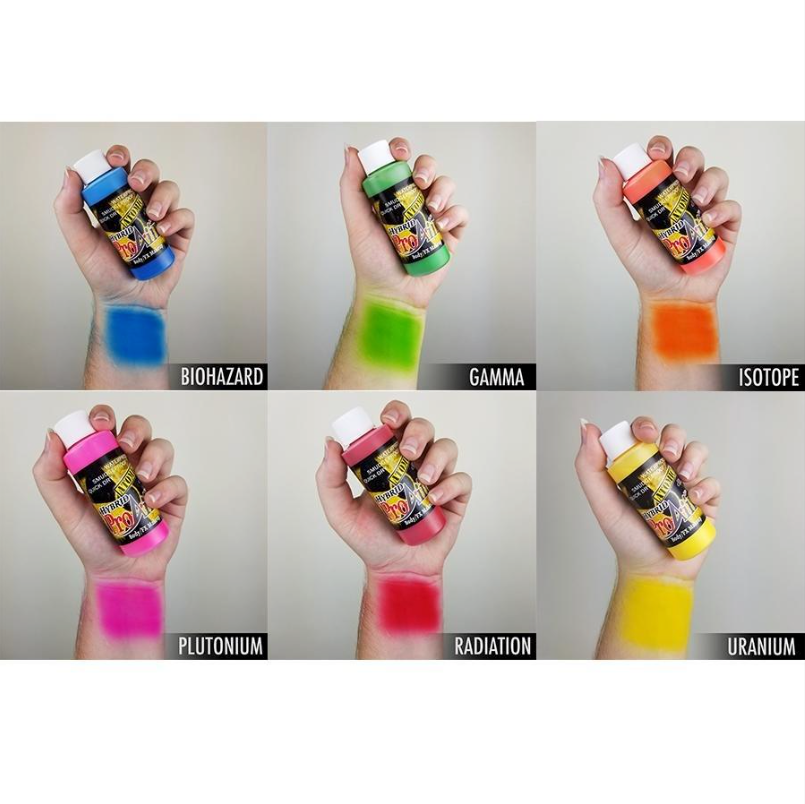 Hands holding bottles of atomic colors  of proaiir brand face body airbrush paint with swatches of color on arm atomic uv neon dayglow