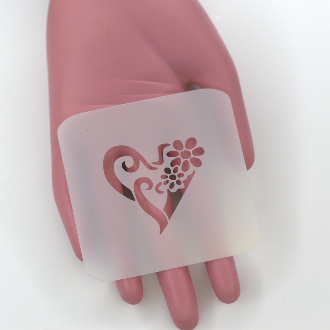 PET Stencil of stylized heart with daisy flowers on pink hand