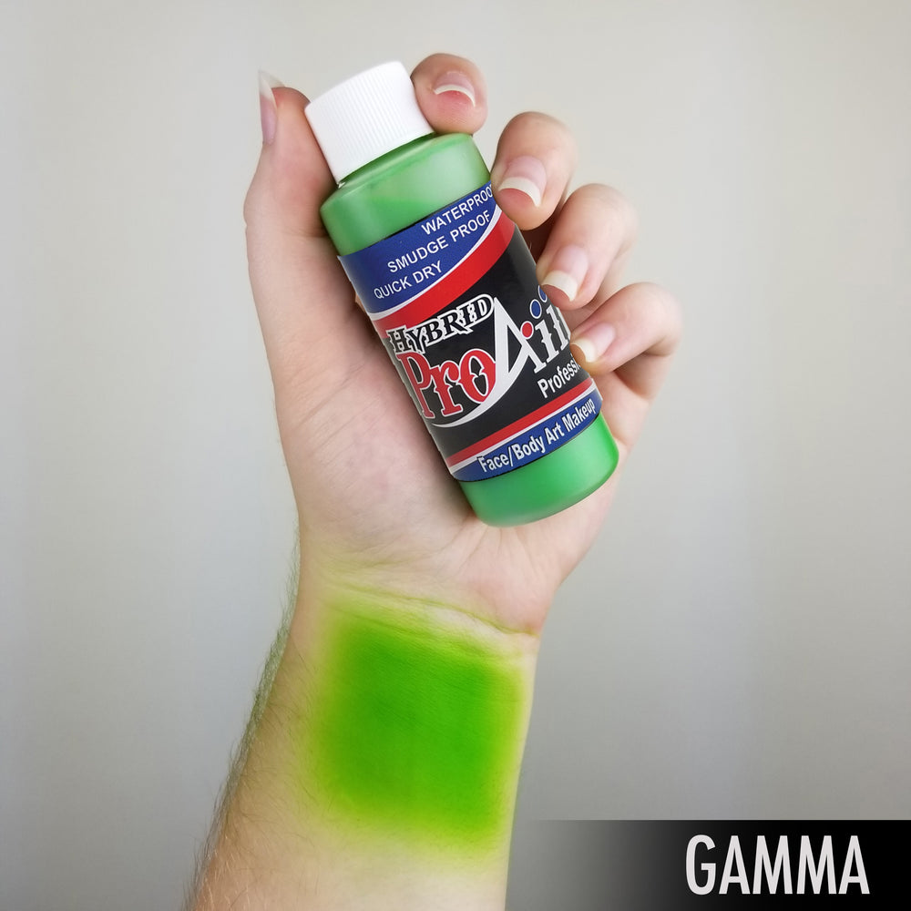 flesh color hand holding bottle of green fac ebody paint makeup with exposed arm showing color swatch
